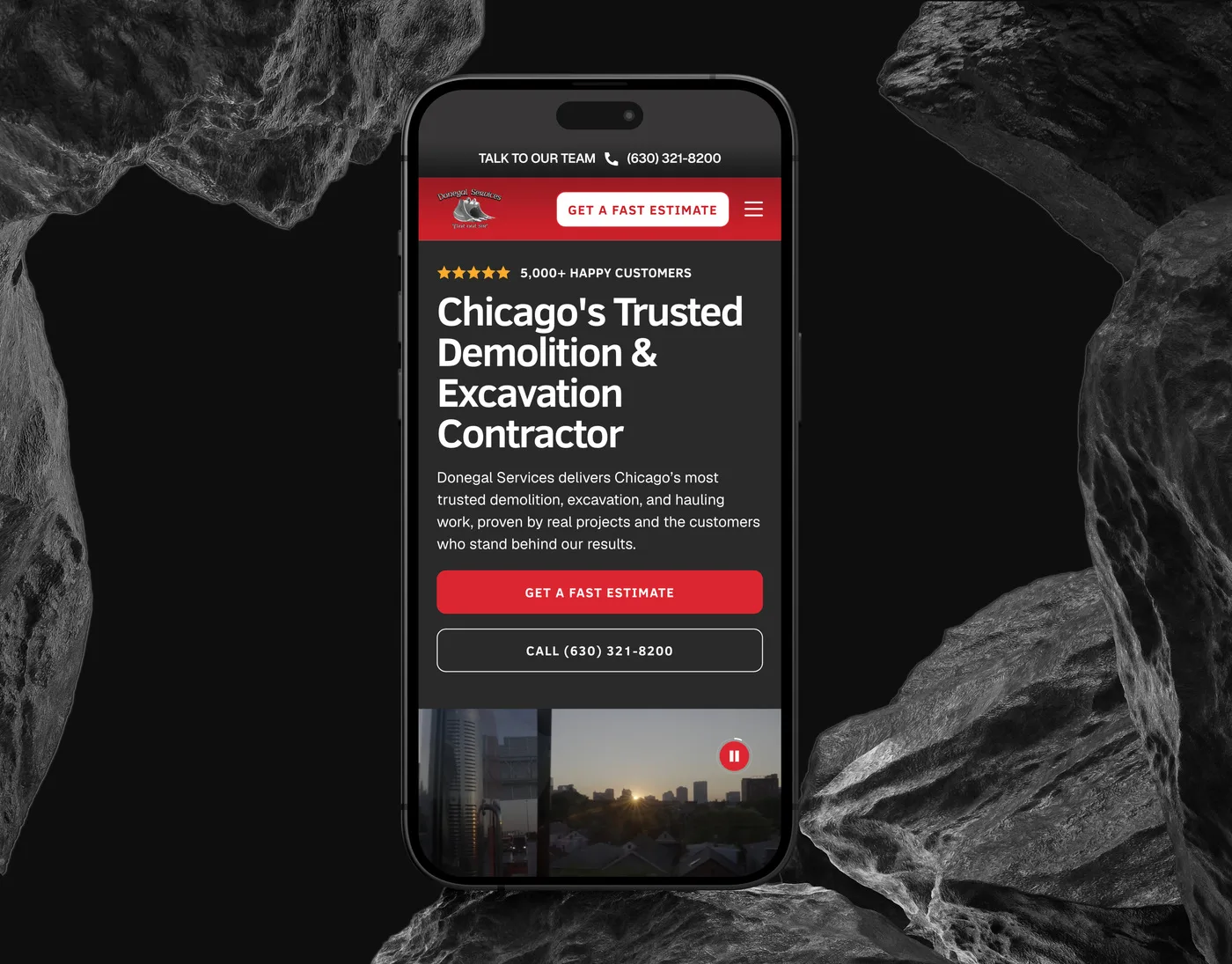 The Donegal Services mobile homepage on an iPhone set upright between dark rocks, headed "Chicago’s Trusted Demolition & Excavation Contractor" above the estimate and call buttons.