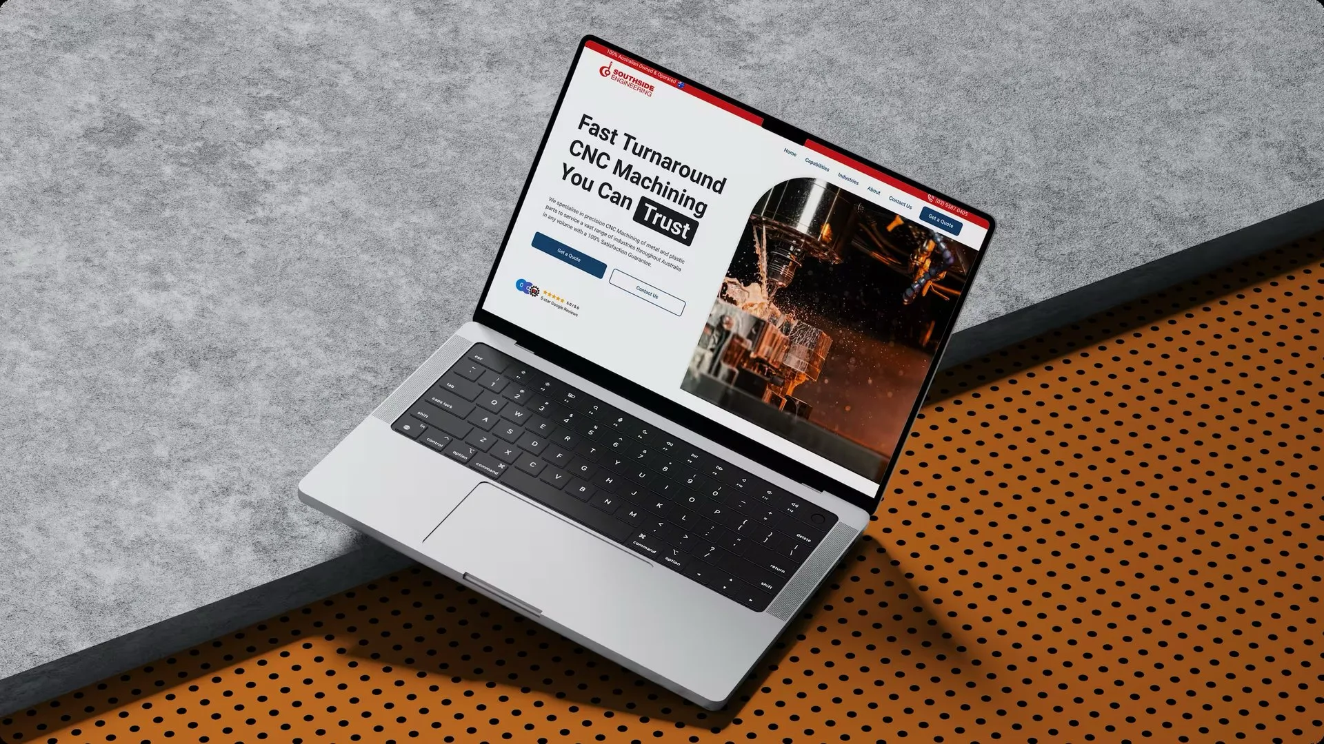 The Southside Engineering homepage open on a MacBook angled across a concrete slab and a perforated orange panel, showing the Fast Turnaround CNC Machining You Can Trust headline beside a photo of a CNC cutter spraying coolant.