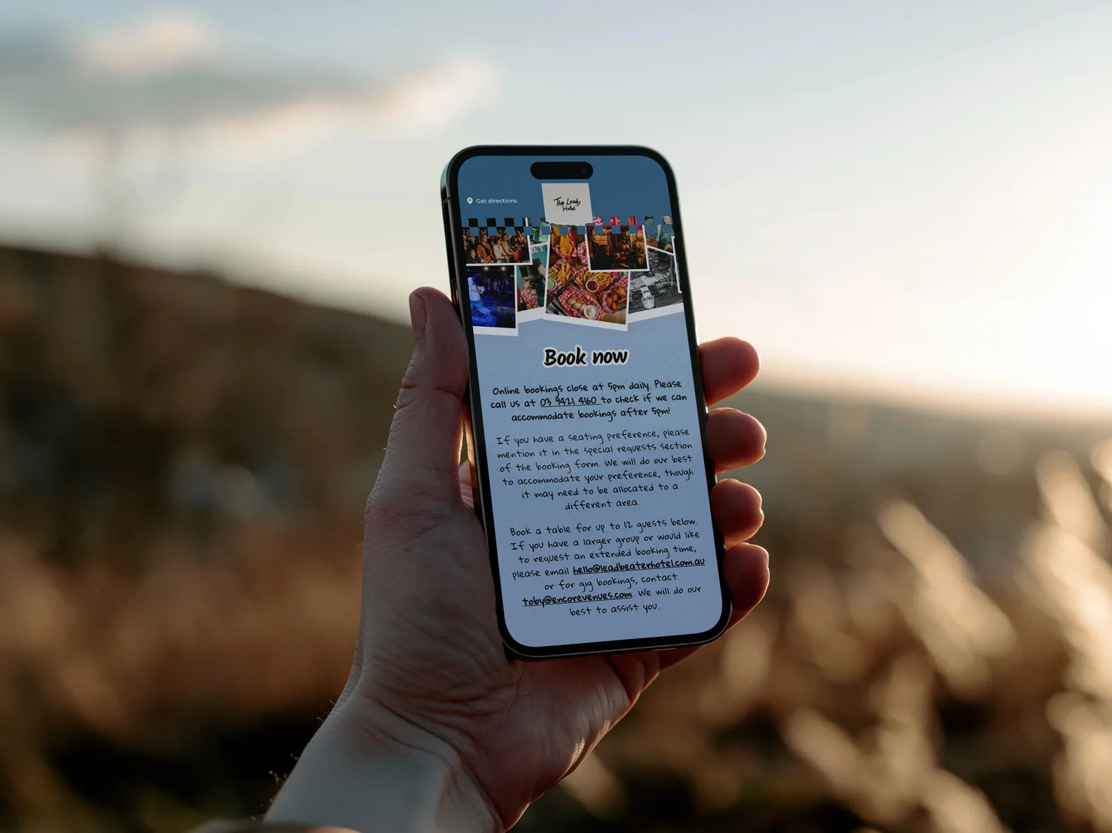 The Leadbeater Hotel booking page on an iPhone held up outdoors at sunset, with the hand-written booking notes above the Book a Table button.